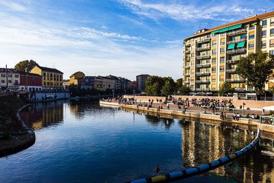 Canal amidst buildings in city against sky