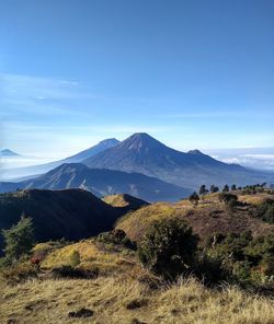 Scenic view of mountains against blue sky