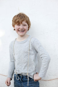 Portrait of smiling girl standing against wall