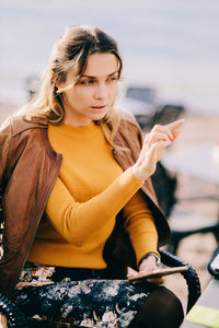 Portrait of young woman sitting at beach