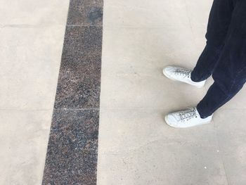 Low section of man standing on tiled floor