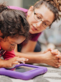 Mother and mixed race daughter at home having fun using a learning tablet computer 