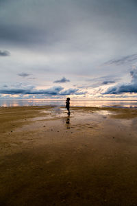 Man standing on beach against sky