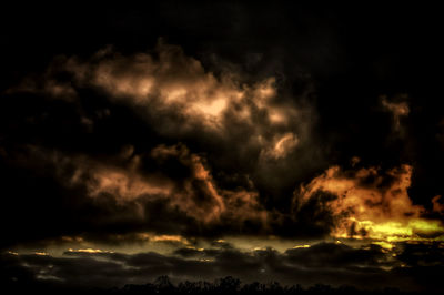 Low angle view of storm clouds in sky during sunset