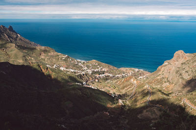 Scenic view of sea and mountains against sky