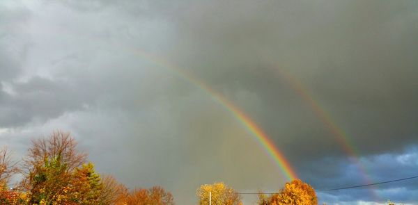 Low angle view of rainbow against cloudy sky