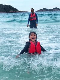 Father and son swimming in sea