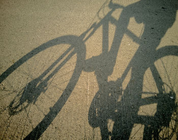 High angle view of shadow of bicycle on road