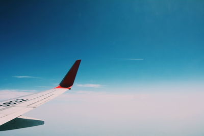 Airplane wing against blue sky