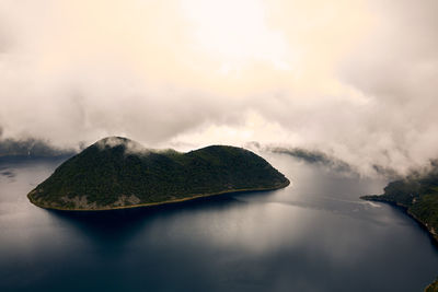 Scenic view of rocks by sea against sky