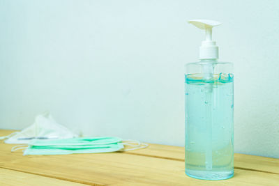 Close-up of blue bottle on table against wall