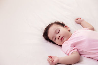 High angle view of baby sleeping on bed