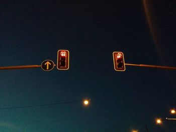 Low angle view of illuminated lighting equipment against sky