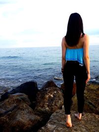 Rear view of woman looking at sea against sky