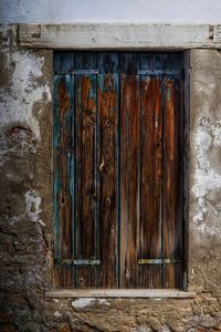 Old weathered wall with closed door