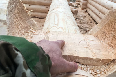 Close-up of hands working on log