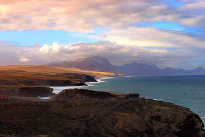 Scenic view of sea and mountains against sky