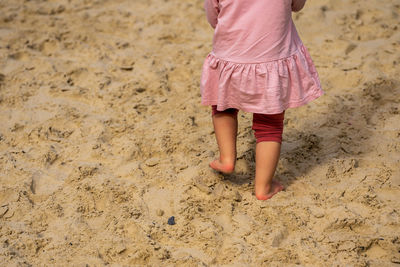 A little child barefoot in the sand