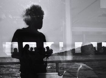 Silhouette people standing by glass window