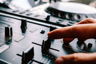 Close-up of cropped hand on control panel of turntable