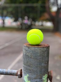 Tennis ball balanced on the net post