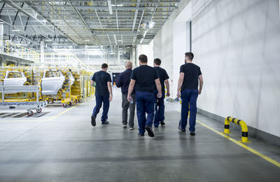 Colleagues having a break and walking in a modern car factory