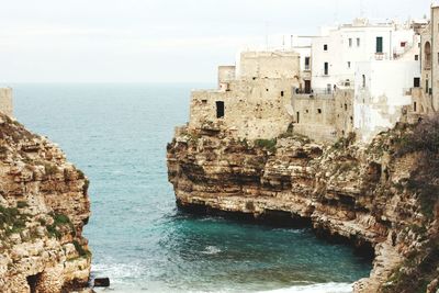 Buildings on cliff by seascape