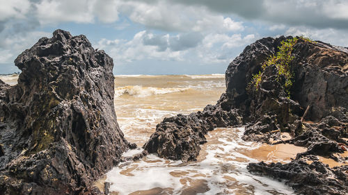 Panoramic view of rock formation in sea against sky