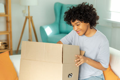 Side view of young woman using laptop while sitting at home