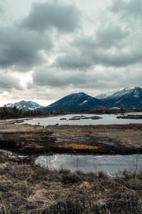 Scenic view of lake by mountains against sky