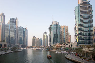 Canal amidst buildings in city against sky. dubai marina