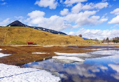 Scenic view of snow covered mountains against blue sky