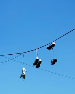 Low angle view of power lines against clear blue sky