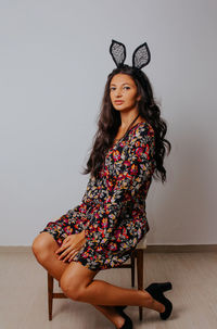 Portrait of woman standing against wall