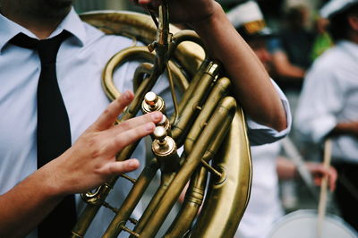 Midsection of man playing guitar at music concert