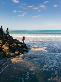 People at beach against sky