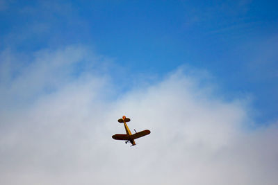 Low angle view of person jumping against sky