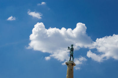 Low angle view of statue against blue sky