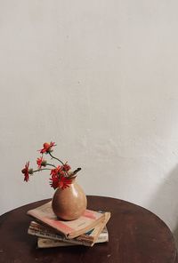 Flower vase on table against wall