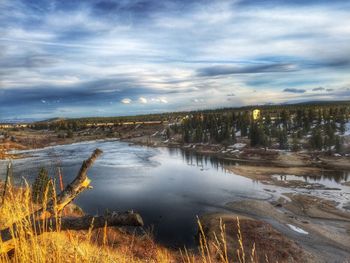 Scenic view of lake against cloudy sky