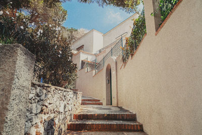 Low angle view of staircase by building against sky