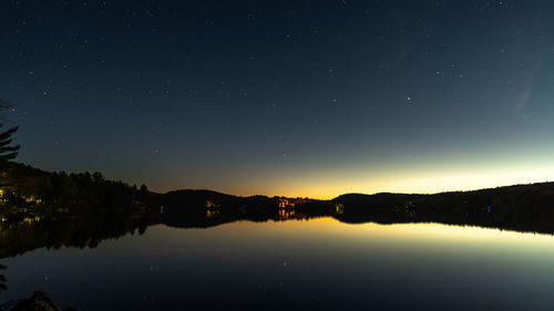 Scenic view of lake against sky at night