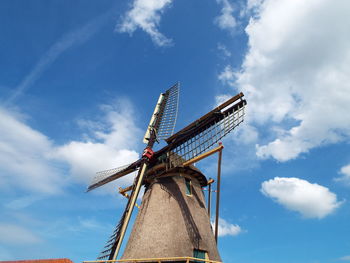 Low angle view of windmill against cloudy sky