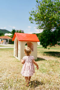 Rear view of girl with umbrella on street