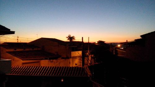 Silhouette buildings against clear sky at sunset