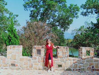 Full length of woman standing against trees