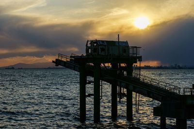 Pier on sea at sunset