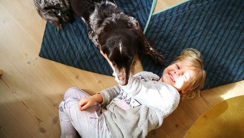High angle view of woman with dog on floor