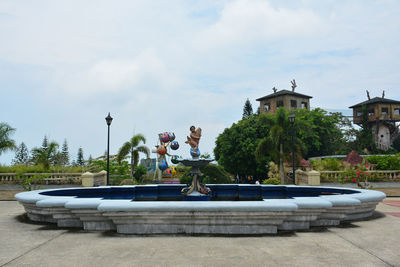 People by swimming pool against sky