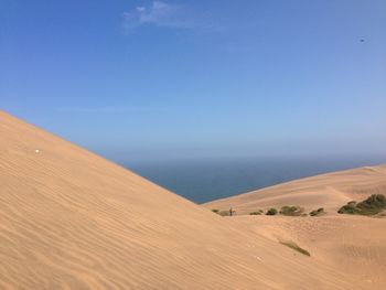 Scenic view of desert against blue sky